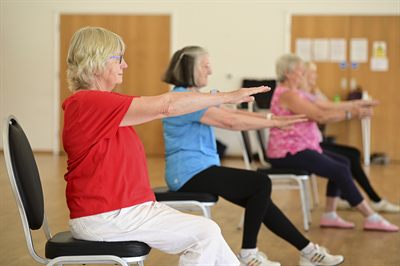 A member exercising while seated on a chair